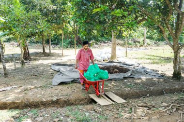 Doğu Luwu, Endonezya - 05 Mayıs 2021: İnsanlar malları taşımak için el arabalarını kullanıyorlar