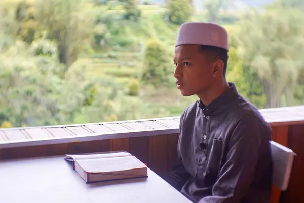 Gowa, Endonezya - 09 Aralık 2022: Ahşap bir evde Kur 'an okuyan öğrenciler