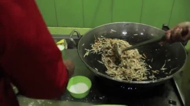 Pangkep, Endonezya - 20 Haziran 2023: İnsanlar kızartma tavasında sebze pişiriyor