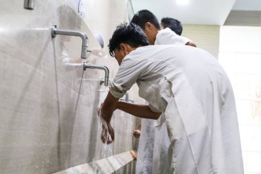 Makassar, Endonezya - 16 Temmuz 2024: Müslüman öğrenciler abdest alıyorlar