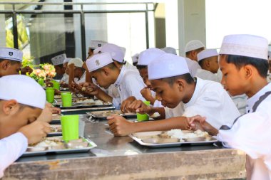 Makassar, Endonezya - 16 Temmuz 2024: Müslüman öğrenciler kantinde birlikte yemek yiyorlar