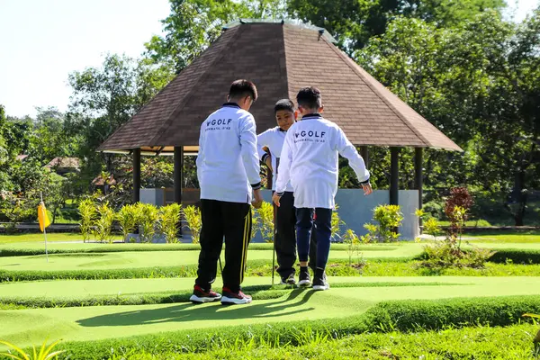 Makassar, Endonezya - 16 Temmuz 2024: İnsanlar güneşli bir günde mini golf oynuyorlar