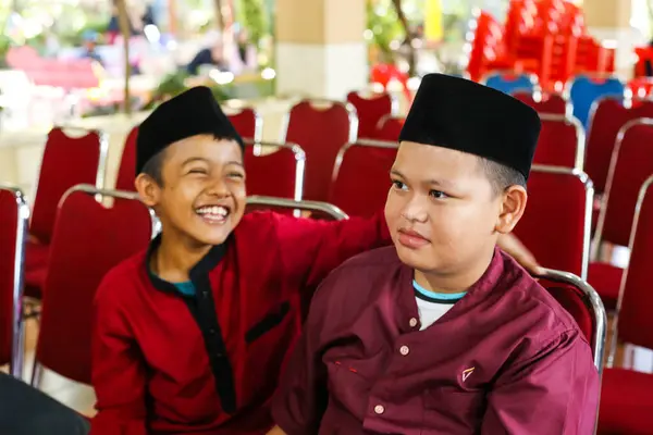 Gowa, Endonezya - 20 Şubat 2024: Sandalyede oturan çok sayıda Müslüman erkek çocuk