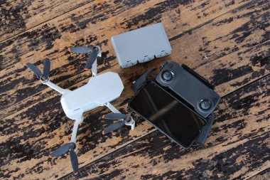 Tahta bir zeminde Mini Drone, Batarya ve Uzaktan Kumanda