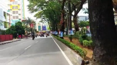 Makassar, Endonezya, 06 Ağustos 2024. Motosikletler ve arabalar şehrin ortasında trafiği geçiyor