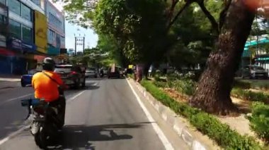 Makassar, Endonezya, 06 Ağustos 2024. Motosikletler ve arabalar şehrin ortasında trafiği geçiyor