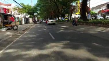 Makassar, Endonezya, 06 Ağustos 2024. Motosikletler ve arabalar şehrin ortasında trafiği geçiyor