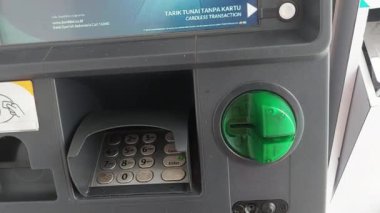 Makassar, Endonezya, 06 Ağustos 2024. Otomatik Veznedar Motosikletleri ve şehrin ortasında trafiği geçen arabalardan para çekiyorlar.