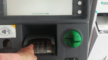 Makassar, Endonezya, 06 Ağustos 2024. Otomatik Veznedar Motosikletleri ve şehrin ortasında trafiği geçen arabalardan para çekiyorlar.