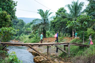 Endonezya, Makassar, 01 Ekim 2024. İnsanlar tahta bir köprüde yürüyorlar.