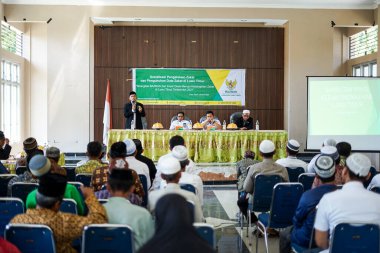 Endonezya, Makassar, 28 Ekim 2024. Oturan insanlar bir seminere katılıyor.