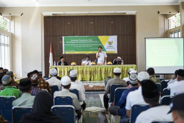 Endonezya, Makassar, 28 Ekim 2024. Oturan insanlar bir seminere katılıyor.