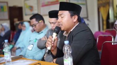 Endonezya, Makassar, 1 Kasım 2024. İnsanlar oturmuş mikrofon kullanarak sorular soruyorlar.