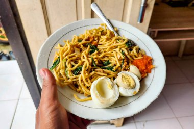 Beyaz bir tabakta erişte ve haşlanmış yumurta.