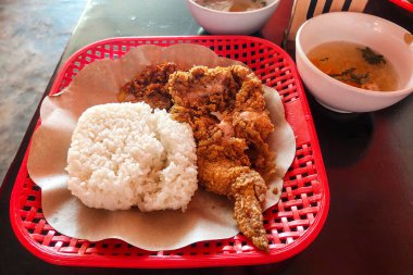 Çıtır tavuk, pilav ve çorba masada.
