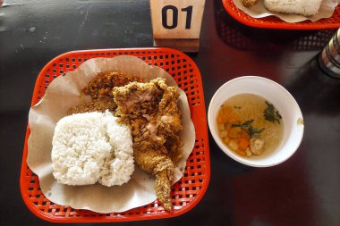 Çıtır tavuk, pilav ve çorba masada.