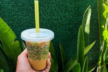 Buzlu cendol tatlısı. Elle tutulan plastik bir fincanda..