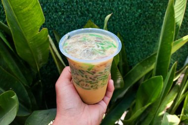 Buzlu cendol tatlısı. Elle tutulan plastik bir fincanda..