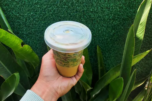 Buzlu cendol tatlısı. Elle tutulan plastik bir fincanda..