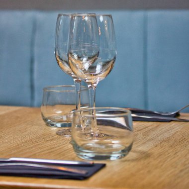 Restoran masası sahnesi: gözlük, masa ve duvar