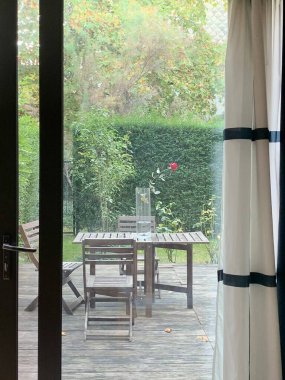 Terasta sandalyeli ahşap masa: Pencereden görüş