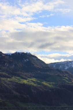 Bulutlu gökyüzünün altındaki güzel yeşil dağlar.