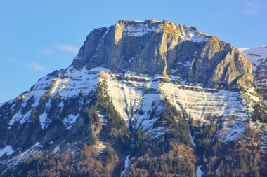 Güneşli bir günde karla kaplı tepeleri olan sihirli dağ manzarası