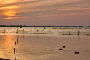 Gölün üzerinde gün batımı ve arka planda su.
