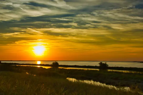 stock image Magnificent sunset over the lagoon in summer, with blue and orange cloudy sky 