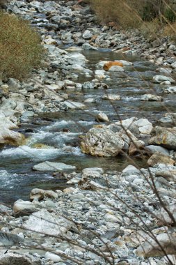 Kışın dağlardaki mavi nehir, kayaların arasından akıyor.