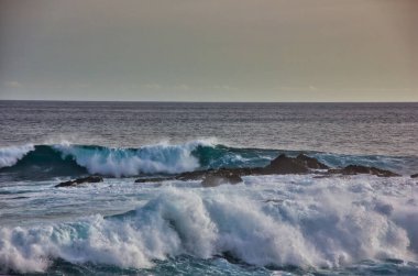 Gün batımında Pasifik Okyanusunda büyüleyici dalgalar.