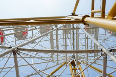 Karnaval, yazın lunaparkta mavi gökyüzünde dönme dolap