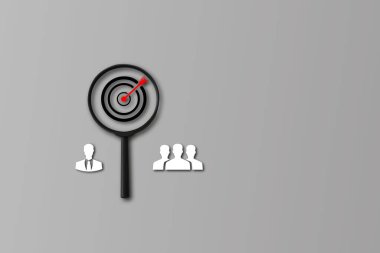 Concept of finding qualified employees, Target board inside magnifier glass for focus quality employee on gray background and copy space. Search, goal, strategy, success. HRM or Human Resource Management