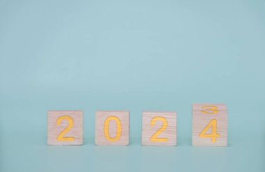 Yeni yıl 2024 konsepti. 2023 sayısıyla Woodblock küpleri mavi arka planda 2023 'ü değiştirmek için kare.