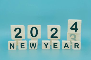 Yeni yıl 2024 konsepti. Yatay tahta bloklar kare ile 2023 numara mavi arkaplan üzerinde 2024 'e değiştirin.