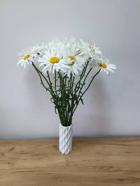 white daisies and a vase with a white vase.