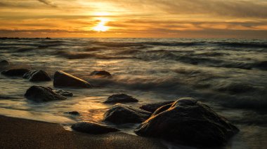 Letvija 'dan Veczemju Klintis, akşam güneş kayalık kıyılarının üzerinde batarken canlanır ve doğanın güzellik ve sükunetinin hüküm sürdüğü görkemli bir manzara yaratır.