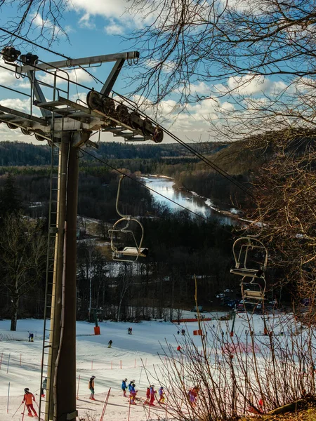 Sigulda 'da, sandalyeden görülebilen Gauja Nehri' nin zeminine uzanan karlı yamaçlardan kayakçılar inerken manzaralar sergiliyor ve kış macera atmosferini daha da güzelleştiriyor.