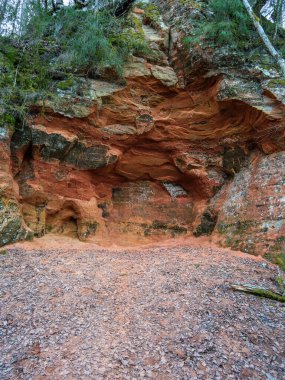 Cesis 'in kızıl kayalıkları Letonya' nın antik geçmişine bir bakış sunuyor, yıpranmış yüzleri milyonlarca yıllık jeolojik evrimin hikayesini anlatıyor.