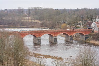 Kendini Kuldiga 'nın her tuğlanın bir hikaye anlattığı ve her kemerin bir anıyı sakladığı kırmızı tuğla köprüsüne daldır.