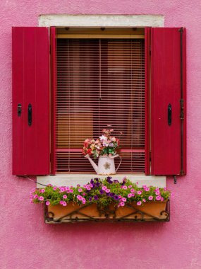 Açık pembe bir pencere hassas bir güzellik katar, Burano 'nun resimsel ve kaprisli karakterini güçlendirir.
