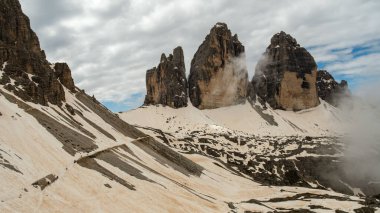 Tre Cime Circuit in June: Snow and fog transforming the Dolomites into a mystical alpine landscape clipart