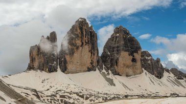 Dolomitlerin karla kaplı ihtişamı: Haziran ayında Tre Cime Circuit 'te bulutlar ve sisle kısmen gizlenmiş zirveler