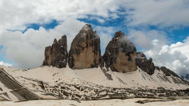 Haziran 'da Dolomitler: Karlı Tre Cime Pisti' nin heybetli zirveleri etrafında dönen bulutlar