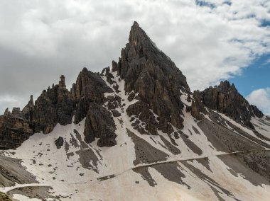 Dolomite zirveleriyle Karlı Tre Cime Pisti yer değiştiren Haziran bulutları tarafından kısmen gizleniyor
