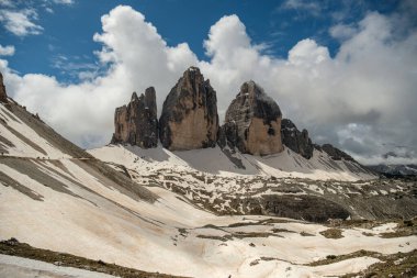 Haziran 'da Dolomitlerin eşsiz güzelliğini yakalayan yemyeşil çimenlerin ön planına karşı kar kaplı Kir Grupları' nın çarpıcı kontrastını deneyimleyin.