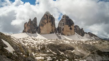 Haziran 'da Dolomitlerin eşsiz güzelliğini yakalayan yemyeşil çimenlerin ön planına karşı kar kaplı Kir Grupları' nın çarpıcı kontrastını deneyimleyin.