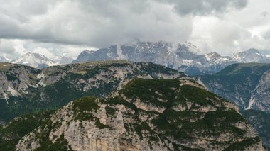 Haziran 'da Dolomitlerin eşsiz güzelliğini yakalayan yemyeşil çimenlerin ön planına karşı kar kaplı Kir Grupları' nın çarpıcı kontrastını deneyimleyin.