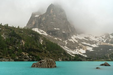 Haziran 'da Dolomitlerin eşsiz güzelliğini yakalayan yemyeşil çimenlerin ön planına karşı kar kaplı Kir Grupları' nın çarpıcı kontrastını deneyimleyin.