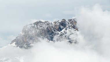 Dolomitlerdeki Haziran büyüsü: Piz Culac 'ın görkemli karla kaplı zirvesi ruhani bulutlarla çevrili